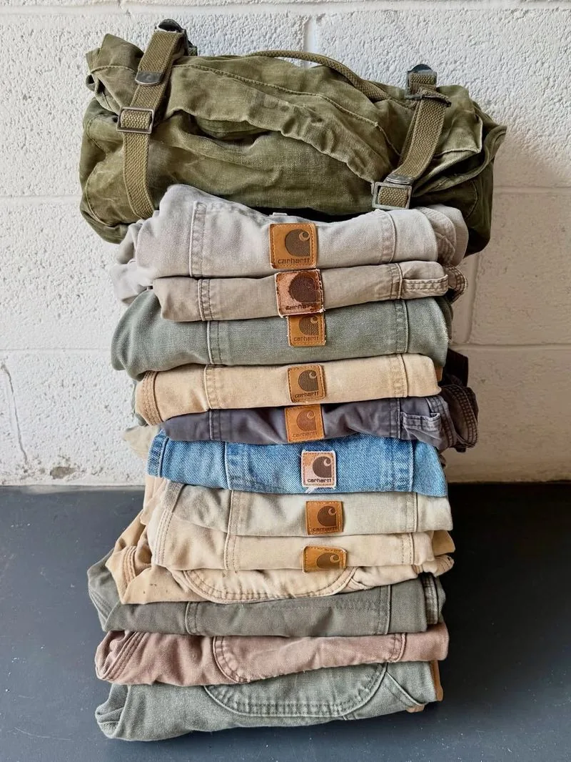 A stack of faded Carhartt work pants