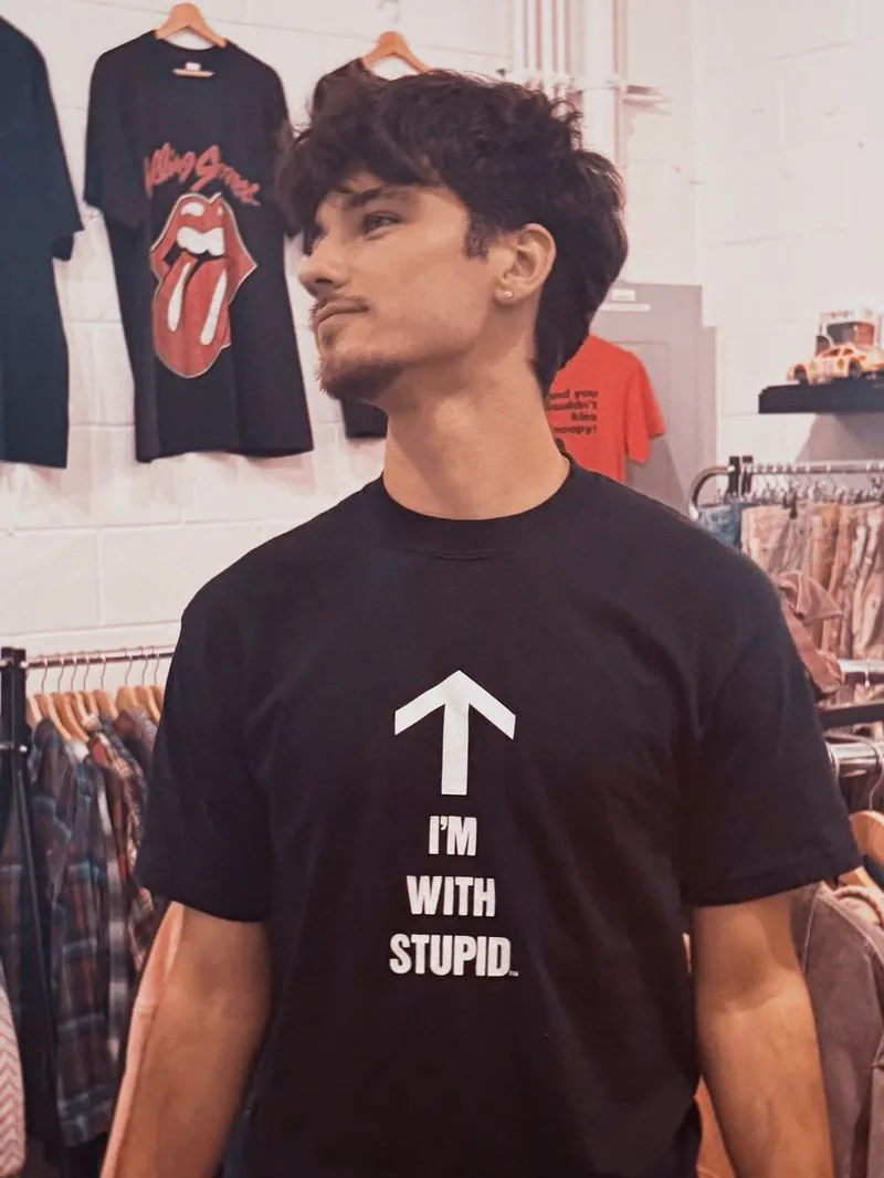 The owner in the shop wearing an I'm With Stupid tee